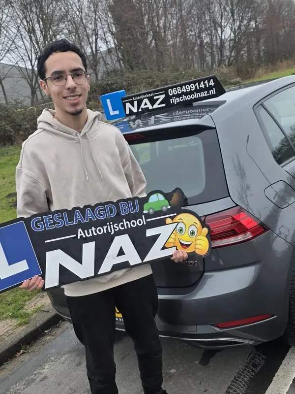 Geslaagde leerling met het bord Geslaagd bij Autorijschool NAZ