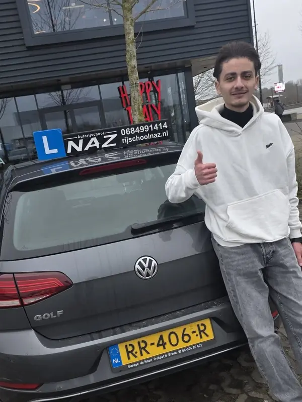 Geslaagde leerling bij de lesauto van NAZ