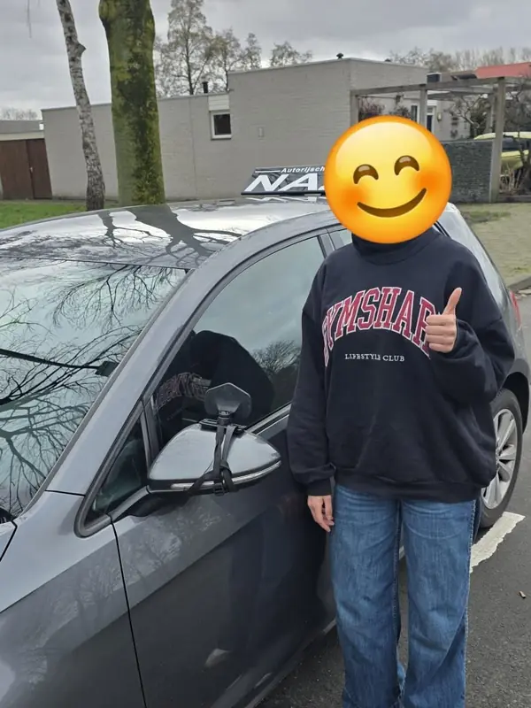 Geslaagde leerling bij de lesauto van NAZ
